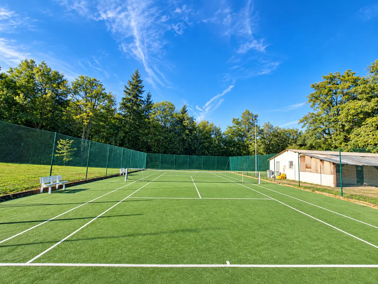 Le court extérieur de Cléré-les-Pins, gazon synthétique vert et club-house